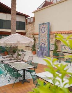 eine Außenterrasse mit Tischen, Stühlen und einem Brunnen in der Unterkunft Belmondo Suites Hare Old Town Antalya in Antalya + 14 Fotos