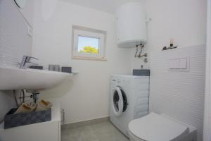 a bathroom with a washing machine and a sink at Apartments - House Monarch - beach, center & shared pool access in Sutivan