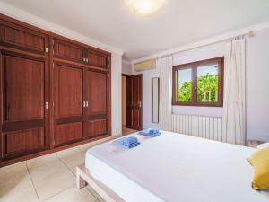 una camera da letto con un grande letto bianco e armadi in legno di Holiday Home Peña Rubia by Interhome a Cala Murada