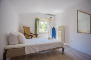 a room with a bed and a chair and a window at Apartments - House Monarch - beach, center & shared pool access in Sutivan +32 photos