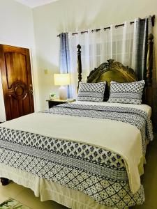 a bedroom with a large bed with blue and white pillows at Olive Breeze in Runaway Bay