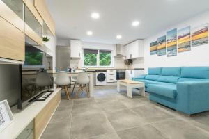 a living room with a blue couch and a kitchen at Laredo Suite 2 in Laredo