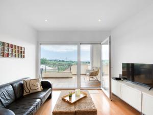 un soggiorno con divano in pelle nera e TV di Apartment Sun Village I by Interhome a Palau-Saverdera