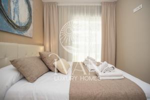 a bedroom with a bed with towels and a fan at Casa Isla Ivan Luxury Homes 1ªPlta Norte 1ªLinea in Oropesa del Mar +16 photos