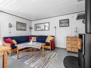 ein Wohnzimmer mit einem blauen Sofa und einem Tisch in der Unterkunft Chalet Sandrabu by Interhome in Øyuvstad