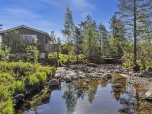ein Haus mit einem Teich und einem Haus in der Unterkunft Chalet Sandrabu by Interhome in Øyuvstad