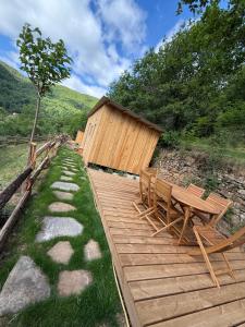 a wooden deck with benches and a wooden hut at M'Belles Cabanes in Viala-du-Tarn