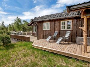 Cabaña con 2 sillas en una terraza de madera en Holiday Home Solfridbu by Interhome, en Øyuvstad