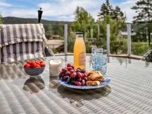 una mesa con una botella de zumo de naranja y un plato de comida en Holiday Home Solfridbu by Interhome, en Øyuvstad 32 fotos más