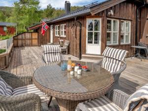 Un patio con una mesa y sillas en una terraza. en Holiday Home Solfridbu by Interhome, en Øyuvstad