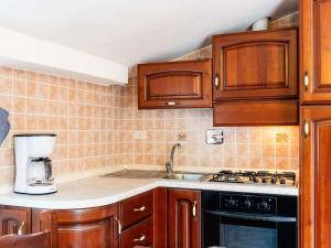 Una cocina con gabinetes de madera y un horno de estufa. en Apartment La Colombera-6 by Interhome, en Diano Castello