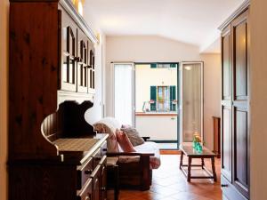 Una sala de estar con un piano y una sala de estar con una ventana. en Apartment La Colombera-6 by Interhome, en Diano Castello