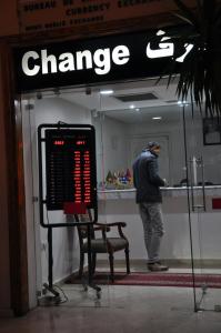 a man standing in front of a change sign at Mont Gueliz in Marrakech