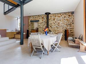 Un comedor con una mesa y sillas y una pared de ladrillos. en Holiday Home La Gicquelière by Interhome, en Jullouville-les-Pins 51 fotos más