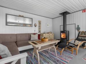 a living room with a couch and a wood stove at Holiday Home Berthabu by Interhome in Øyuvstad