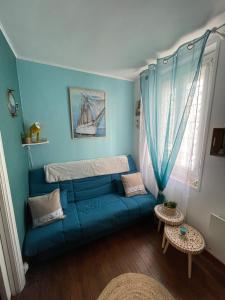 a living room with a blue couch and a window at Côte & Mer in Fécamp