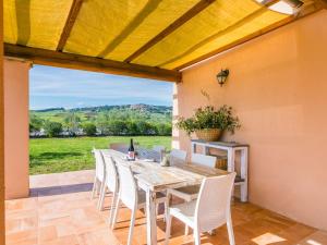 jadalnia ze stołem i krzesłami na patio w obiekcie Holiday Home Il Fienile by Interhome w mieście Bibbona