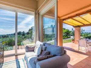 salon z kanapą i dużymi oknami w obiekcie Holiday Home Il Fienile by Interhome w mieście Bibbona