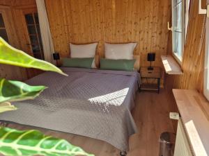 ein Schlafzimmer mit einem Bett in einem Holzzimmer in der Unterkunft Cosy Cottage in Braunfels