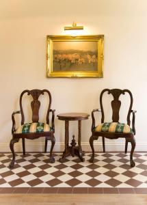 two chairs and a table with a picture on the wall at Rose Park Hotel in London