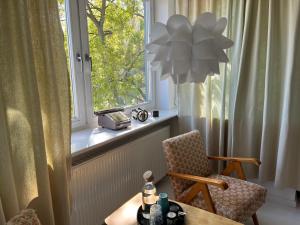 Una sala de estar con una silla y una ventana. en Lalala, en Sopot