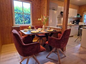 eine Küche mit einem Holztisch mit Stühlen und einem Esszimmer in der Unterkunft Cosy Cottage in Braunfels