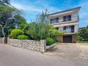 dom z kamienną ścianą przed nim w obiekcie Apartment Kraljic by Interhome w mieście Kornić