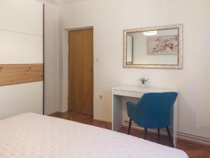 sypialnia z biurkiem i niebieskim krzesłem w obiekcie Apartment Kraljic by Interhome w mieście Kornić