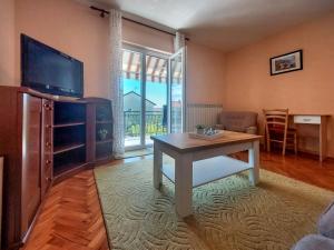 salon ze stołem i telewizorem w obiekcie Apartment Kraljic by Interhome w mieście Kornić