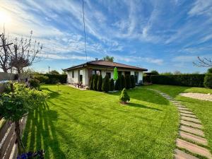 a yard with a house with a green lawn at Sea You Guest House in Ezerets