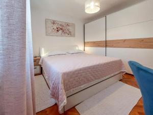 sypialnia z łóżkiem i niebieskim krzesłem w obiekcie Apartment Kraljic by Interhome w mieście Kornić