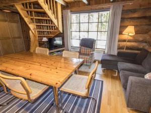 ein Wohnzimmer mit einem Holztisch und Stühlen in der Unterkunft Holiday Home Örtsylä a by Interhome in Salla