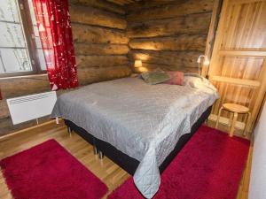 ein Schlafzimmer mit einem Bett in einer Blockhütte in der Unterkunft Holiday Home Örtsylä a by Interhome in Salla + 11 Fotos