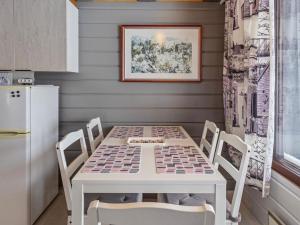 eine Küche mit Tisch und Stühlen und einem Kühlschrank in der Unterkunft Holiday Home Mustalampi 5 satakieli by Interhome in Ruka
