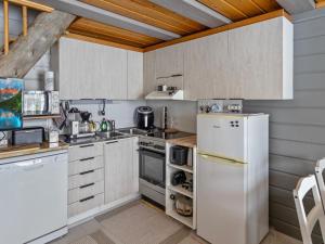 eine Küche mit weißen Geräten und Holzdecken in der Unterkunft Holiday Home Mustalampi 5 satakieli by Interhome in Ruka
