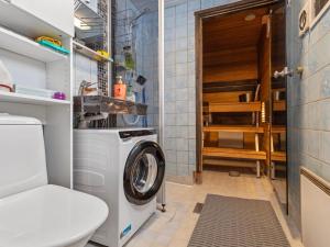 eine Waschmaschine in einem Badezimmer mit Toilette in der Unterkunft Holiday Home Mustalampi 5 satakieli by Interhome in Ruka + 12 Fotos
