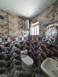 a bathroom with a toilet and a fish themed wall at Pova Hotel Suits and Apartments in Rawalpindi +47 photos