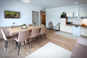 a kitchen and dining room with a wooden table and chairs at Aquarius Apartments in Miskolctapolca