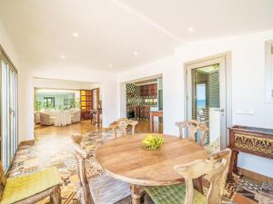 a dining room with a wooden table and chairs at Holiday Home Xoroi by Interhome in Colonia de Sant Pere