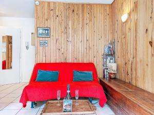 a red bed in a room with two wine glasses at Apartment La Comtesse-9 by Interhome in Saint-Gervais-les-Bains