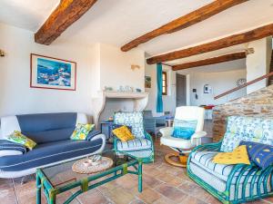 salon z kanapami i krzesłami oraz kominkiem w obiekcie Villa Villa Etoile Filante by Interhome w mieście Le Lavandou