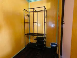 a shelf in a room with a yellow wall at Rainbow Tioman Cottage in Kampong Juara