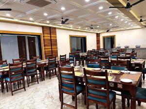 a dining room with wooden tables and chairs at Hotel Holy Pushkar by DIV Hospitality in Pushkar