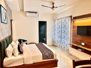 a bedroom with a bed and a flat screen tv at Hotel Holy Pushkar by DIV Hospitality in Pushkar