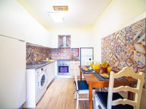 een keuken met een tafel, een wastafel en een vaatwasser bij Holiday Home Eugênia by Interhome in Paderne