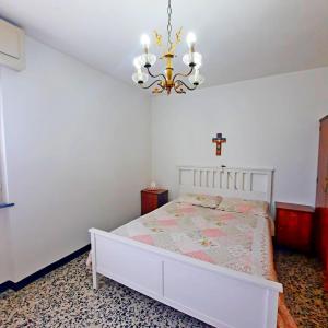 a bedroom with a bed with a cross on the wall at Casa Maioli - Your Mountain Holiday in Casargo