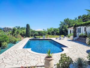 una piscina en un patio con patio y una casa en Villa Aurval by Interhome, en Cogolin