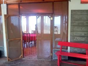 una panchina rossa seduta davanti a una porta di Miliki Maasai Mara a Maasai Mara National Reserve