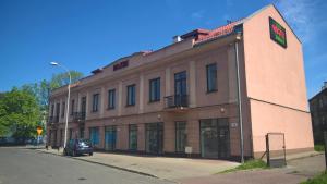 a building with a car parked in front of it at Hostel Maxim in Warsaw