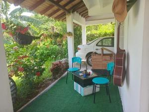 a porch with two chairs and a table and a car at Trekkers haven Enjoy Colombia Ecoliving in Piedecuesta +17 photos